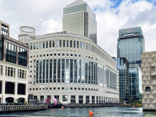 A photograph of 10 South Colonnade taken on a sunny day from across the Wharf